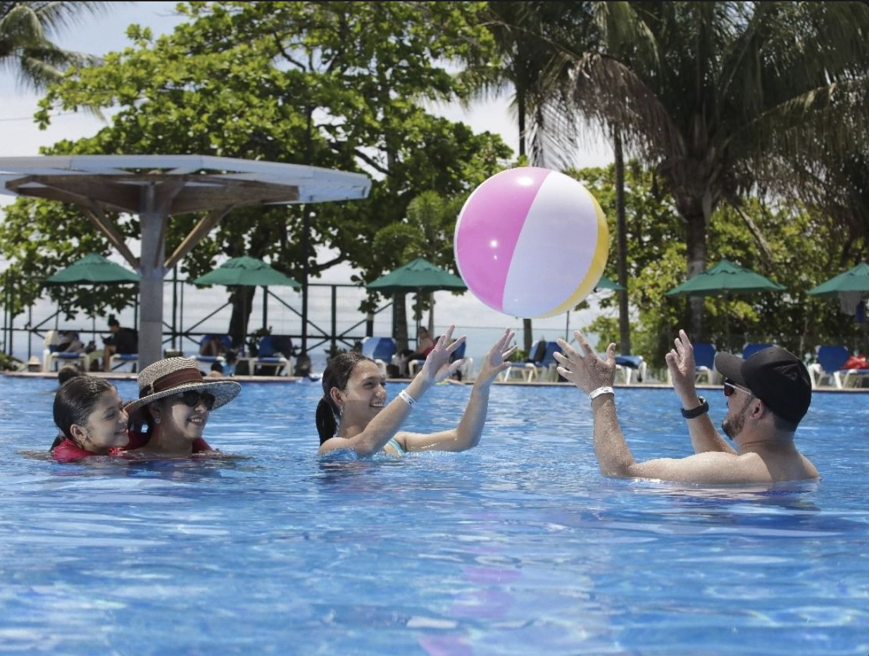 A family playing with a ball in one of the club's pools